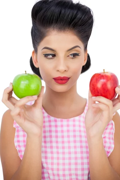 Modelo de pelo negro pensativo sosteniendo manzanas — Foto de Stock