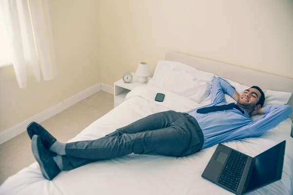 Homem alegre relaxando em sua cama — Fotografia de Stock