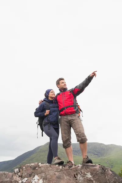 Couple debout sur un rocher regardant les montagnes — Photo