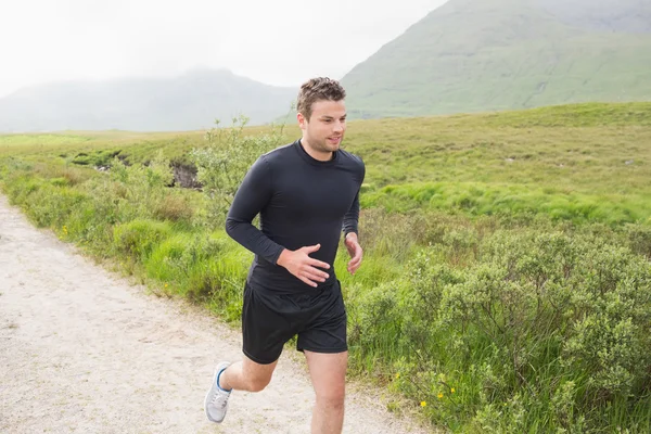 Fit mens joggen op een parcours — Stockfoto