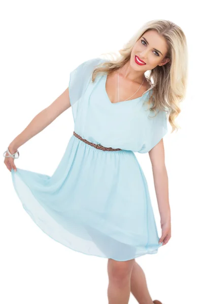 Entzücktes blondes Model im blauen Kleid posiert mit ihrem Kleid — Stockfoto
