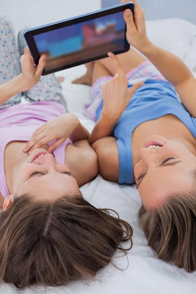 Vrienden kijken naar Tablet PC in bed — Stockfoto