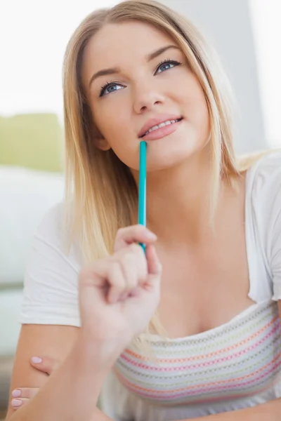 Thoughtful woman holding colour pencil — Stock Photo, Image