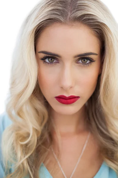 Portrait of a severe blonde woman in blue dress looking at camera — Stock Photo, Image