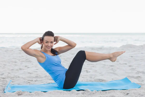 Mulher fazendo crunches abdominais no tapete de exercício — Fotografia de Stock