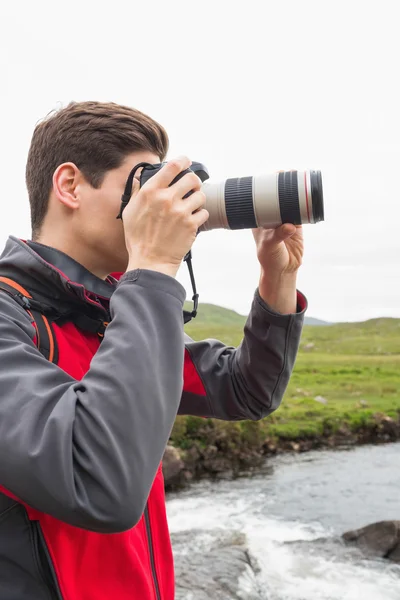 Brunette man on a hike taking a photograph — Stock Photo, Image