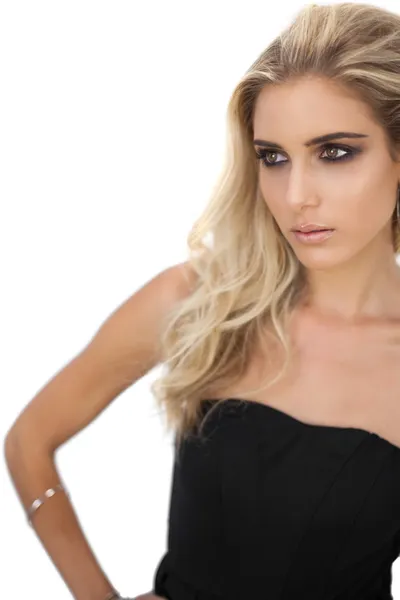 Hermosa modelo rubia en vestido negro posando mirando hacia otro lado — Foto de Stock