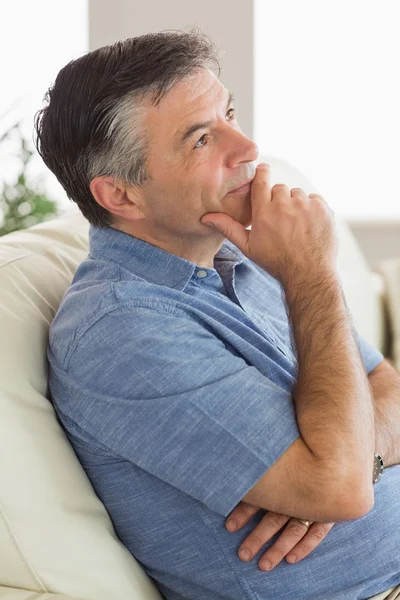 Pensant homme assis sur le canapé — Photo