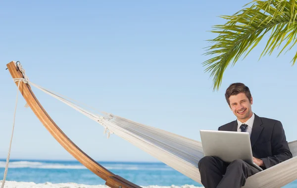 Zakenman zitten in hangmat met behulp van laptop camera kijken — Stockfoto