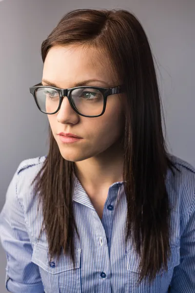 Durchdachte hübsche Brünette mit Brille posiert — Stockfoto