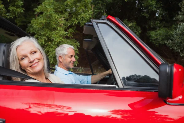 Seitenansicht eines reifen Paares, das rotes Cabrio fährt — Stockfoto