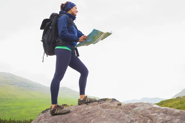 Mujer de pie sobre una roca sosteniendo mapa —  Fotos de Stock