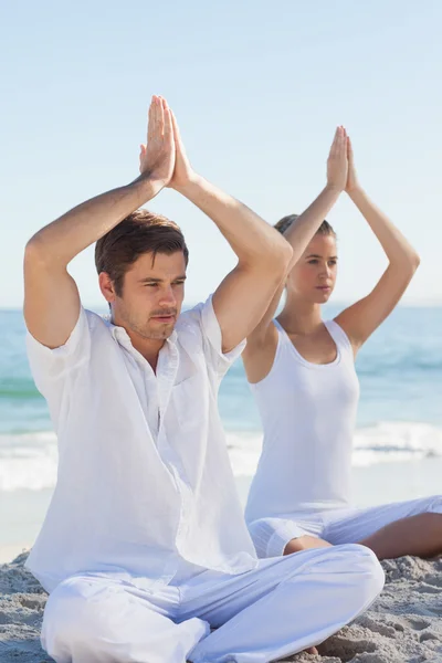 Koncentrerad kvinna och man utövar yoga — Stockfoto