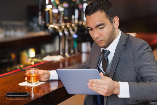 Hombre de negocios serio trabajando en su tableta — Foto de Stock