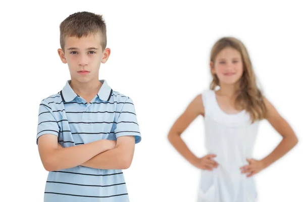 Serious child posing while his sister smiling — Stock Photo, Image