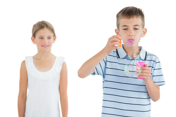 Boy making bubbles while his sister looking at him — Stock Photo, Image