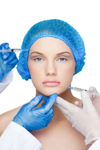 Surgeons making injection on content blonde wearing blue surgical cap — Stock Photo, Image