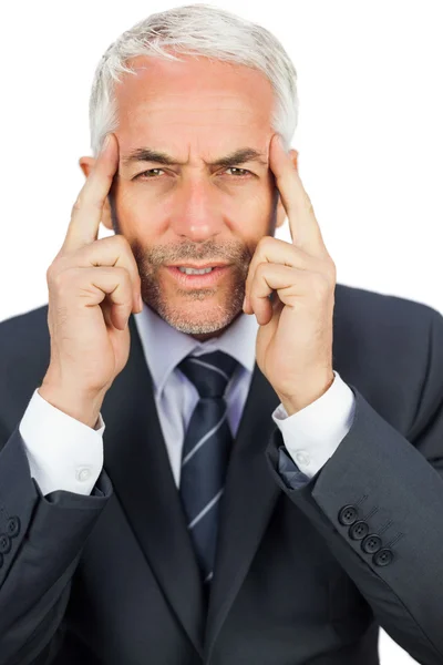 Concentrated businessman holding his temples — Stock Photo, Image