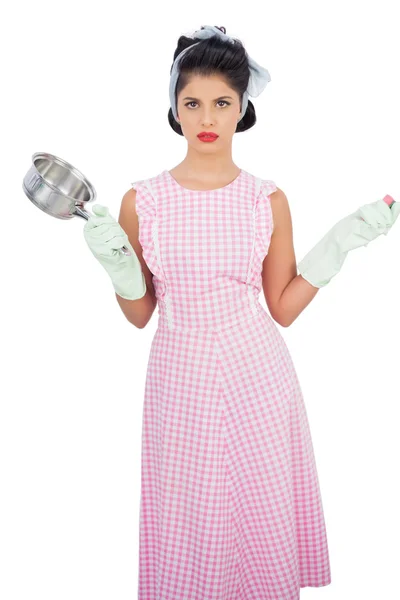 Disppointed black hair model holding a pan and wearing rubber gloves — Stock Photo, Image