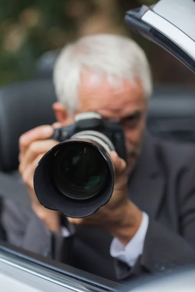 Mature paparazzi taking picture Royalty Free Stock Images