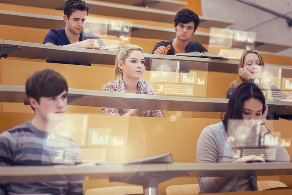 Concentrated students in lecture hall working on their futuristic tablet — Stock Photo, Image