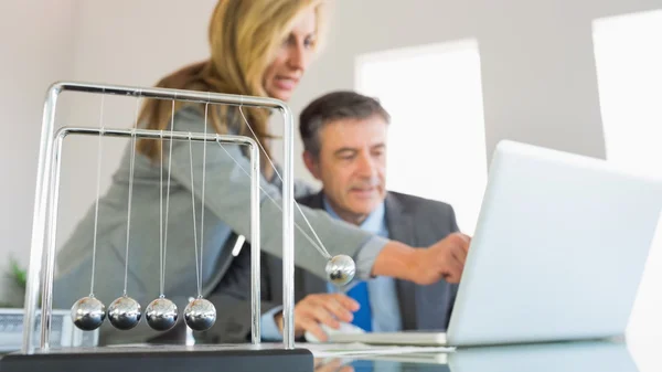 Geschäftsfrau erklärt einem konzentrierten Geschäftsmann etwas am Computer — Stockfoto