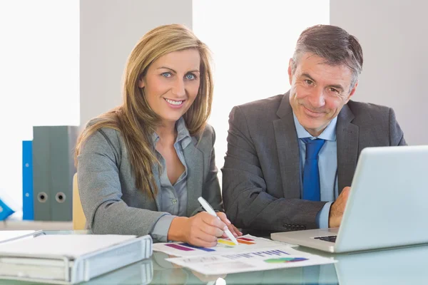 Dos empresarios concentrados sonriendo a la cámara tratando de entender las cifras —  Fotos de Stock