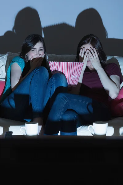 Dva přátelé na gauči sledovat scary movie společně ve tmě — Stock fotografie