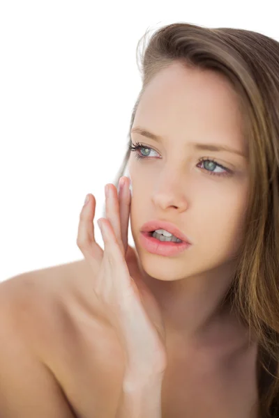 Thoughtful brunette model rubbing her cheek with cream — Stock Photo, Image