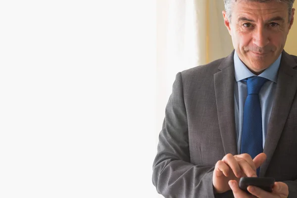 Amused man texting on his mobile phone — Stock Photo, Image