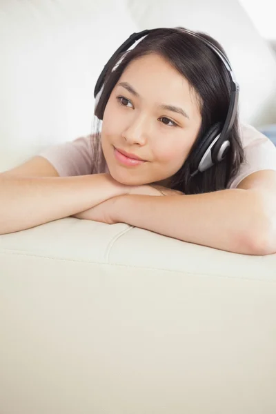 Contenuto ragazza asiatica sdraiata sul divano e ascoltare musica — Foto Stock