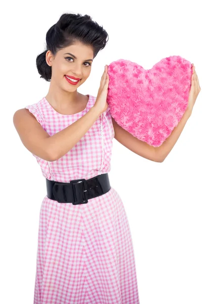 Playful black hair model holding a pink heart shaped pillow — Stock Photo, Image