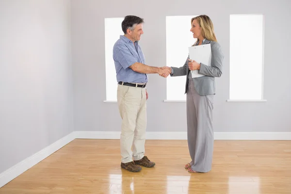 Serious realtor shaking the hand of her buyer — Stock Photo, Image