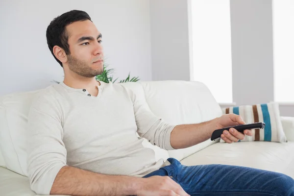 Serious man holding remote control — Stock Photo, Image