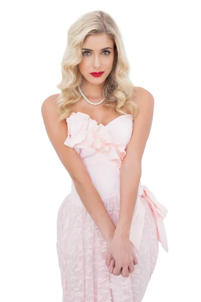 Kijkende blonde model in roze jurk poseren camera kijken en houden haar handen — Stockfoto