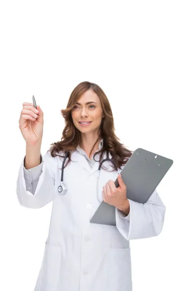 Doctor holding clipboard and pointing at something — Stock Photo, Image