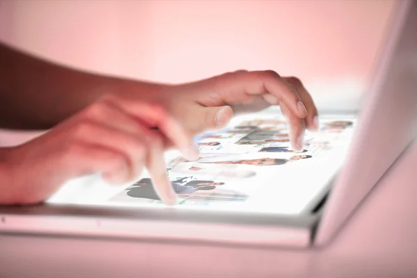 Närbild på händerna plockar bilder på en futuristisk laptop — Stockfoto