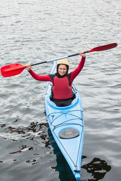 Happy woman in a kayak cheering at the camera — Stock Photo, Image