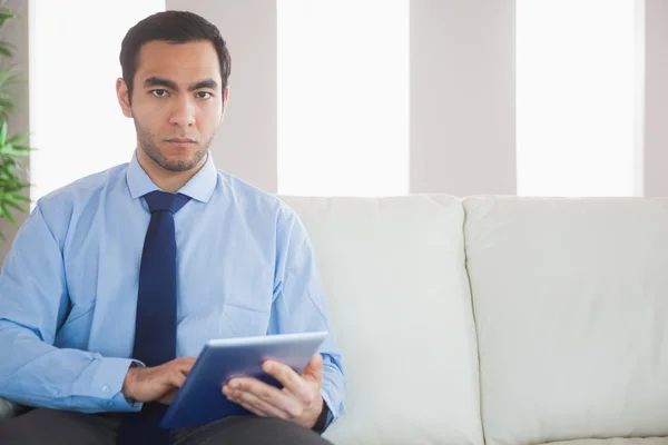 Hombre de negocios con clase unsmiling usando la PC de la tableta — Foto de Stock