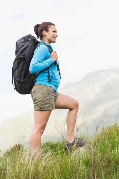 Atractivo excursionista con mochila caminando cuesta arriba — Foto de Stock