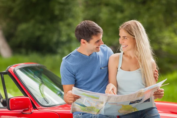 Happy young couple reading map — Stock Photo, Image