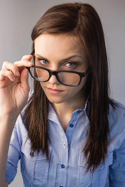 Serious brunette holding glasses posing — Stock Photo, Image