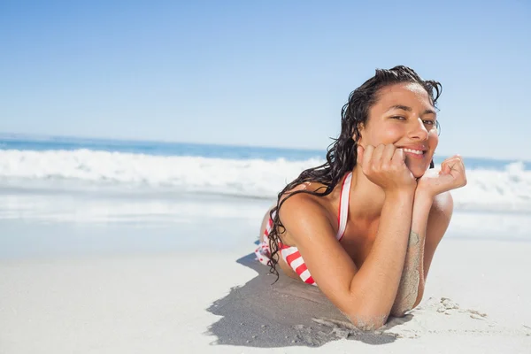 Smiling woman lying down on beach — Stock Photo, Image