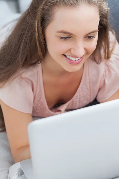 Vrouw liggend op de Bank met behulp van laptop — Stockfoto