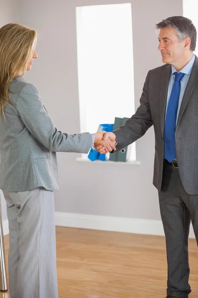 Business team shaking hands and smiling — Stock Photo, Image