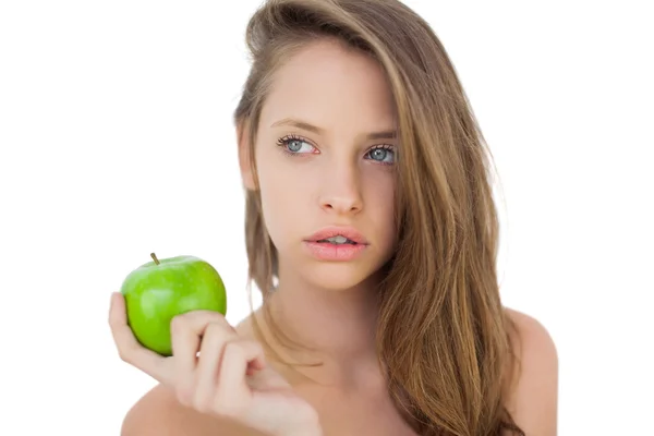 Wondering brunette model holding an apple — Stock Photo, Image