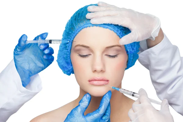 Surgeons making injection on calm blonde — Stock Photo, Image