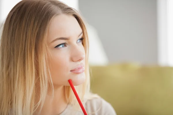 Thoughtful woman holding red pen — Stock Photo, Image