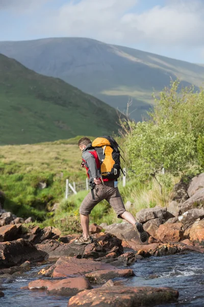 Man crossing a river on a hike — Stock Photo, Image