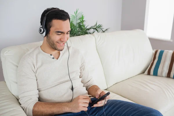 Sorrindo homem bonito ouvindo música — Fotografia de Stock